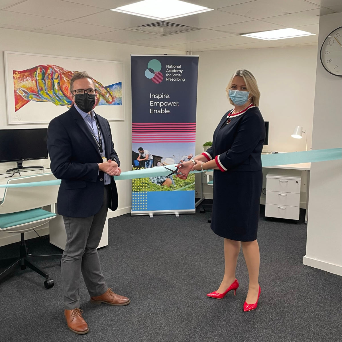 James Sanderson and Prof Dame Helen Stokes Lampard cut a blue ribbon with scissors to mark the opening of NASP's office at the Southbank Centre in London.