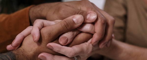 A closeup of to hands clasped together in support