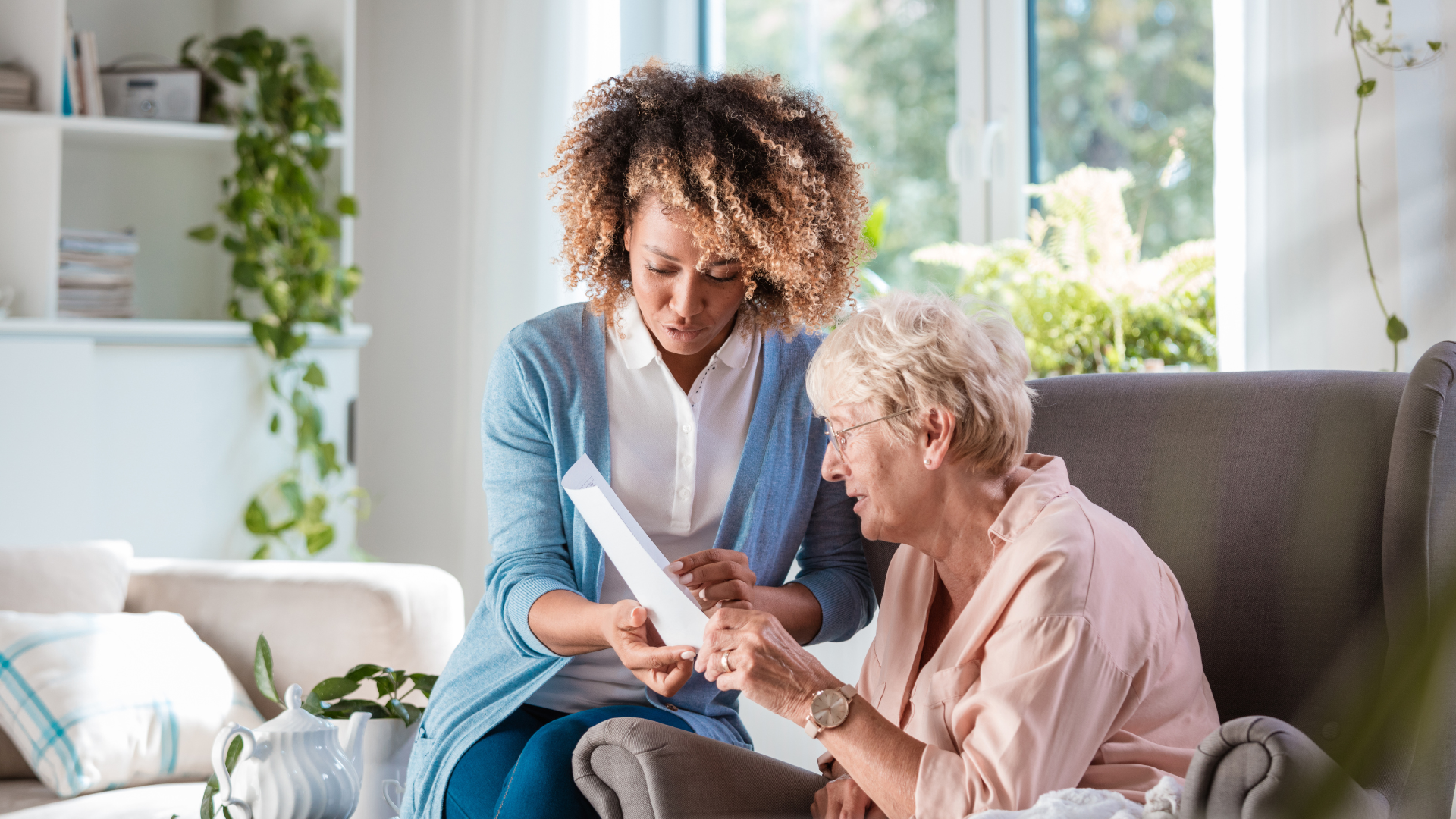 Black woman talks to an elderly woman, she shows her a piece of paper 