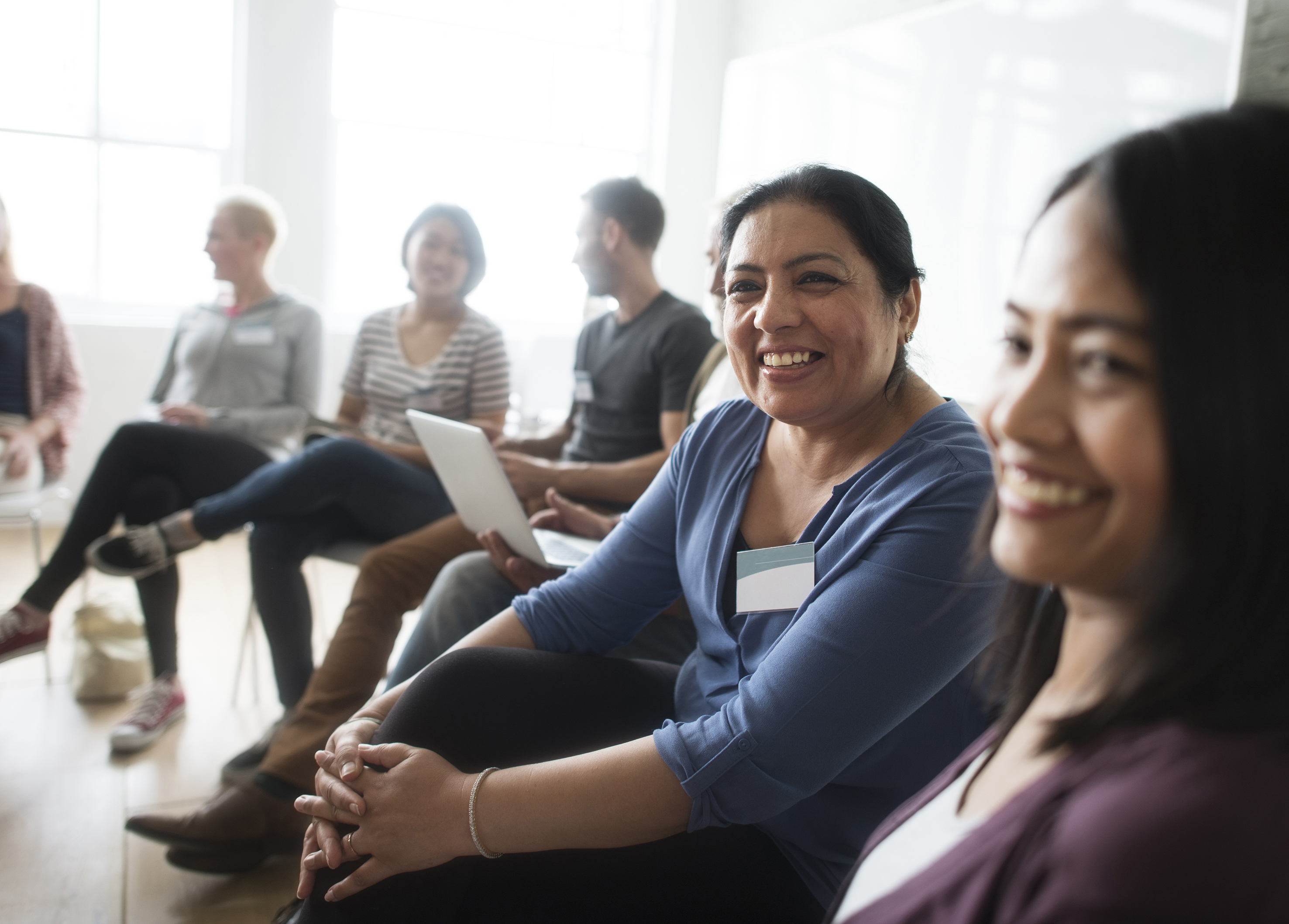 A smiling group of people sitting in a circle together
