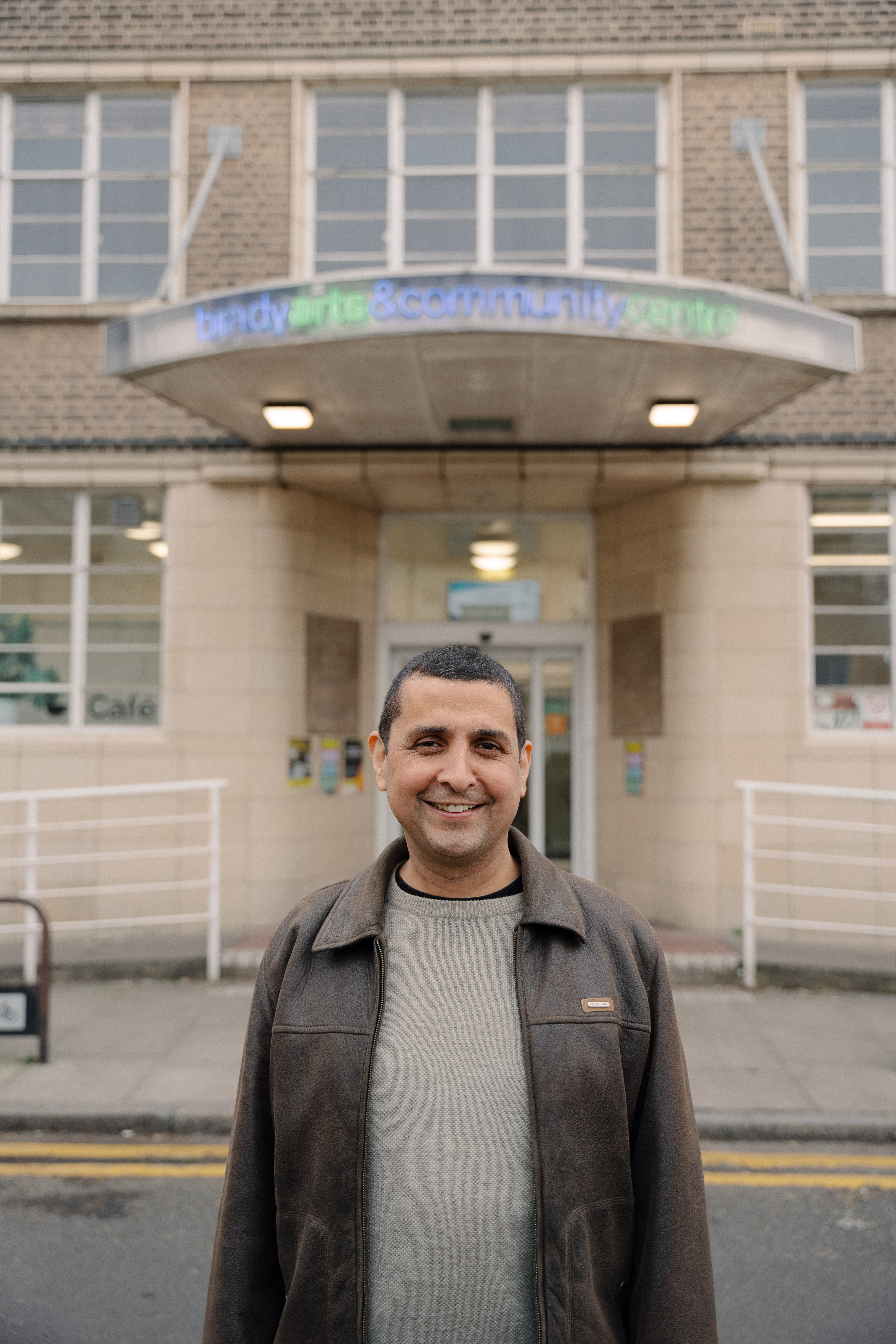 A man stands and poses for a photo outside a London theatre