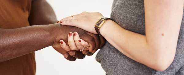 Two people clasp hands 