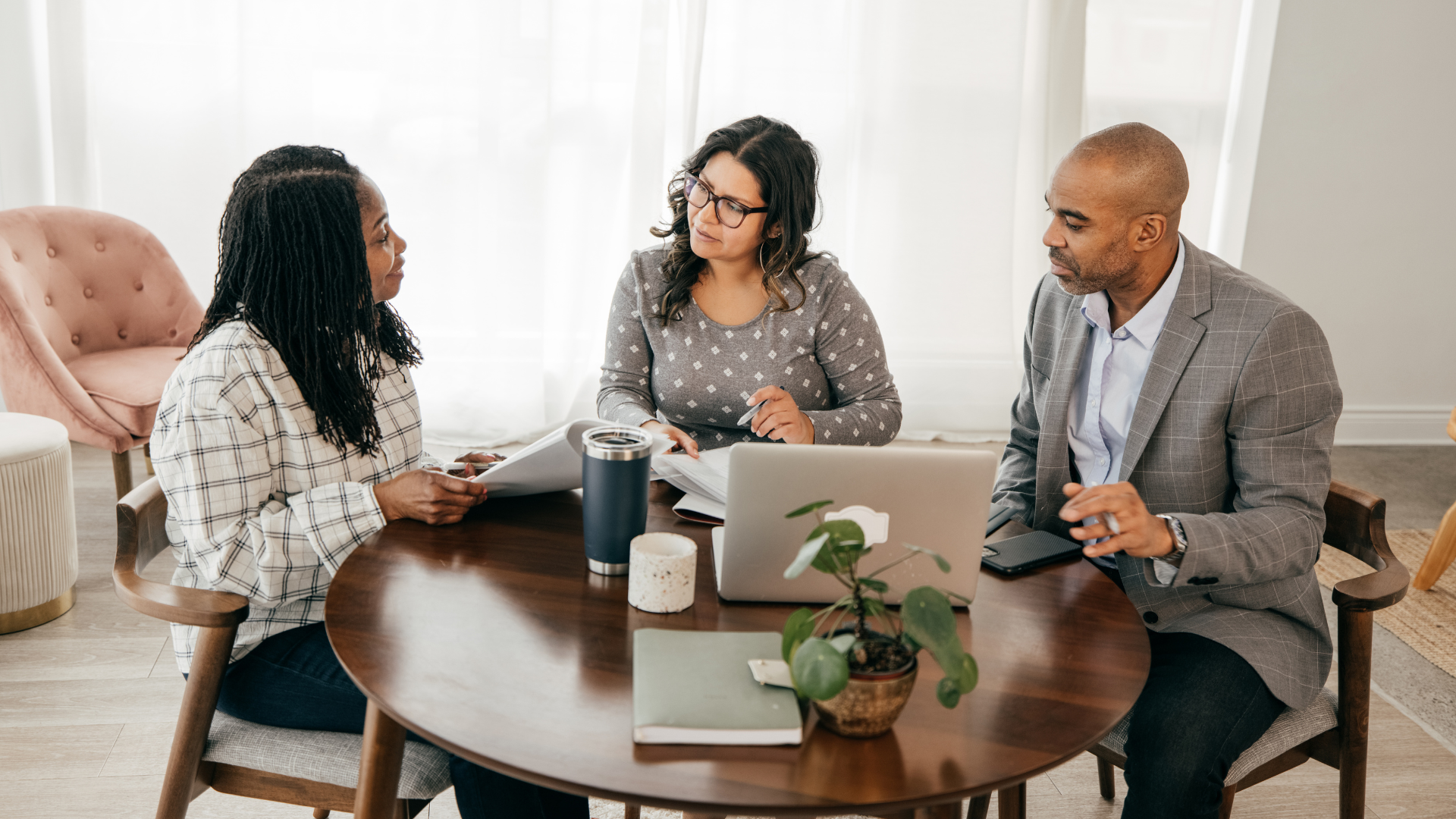 People sitting together at table working on computer and talking about training