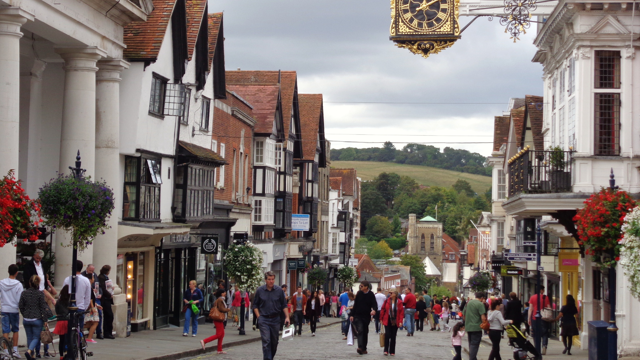 Guildford High Street in Surry on a busy day with rolling hills in the background 