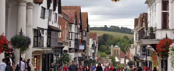 Guildford High Street in Surry on a busy day with rolling hills in the background 