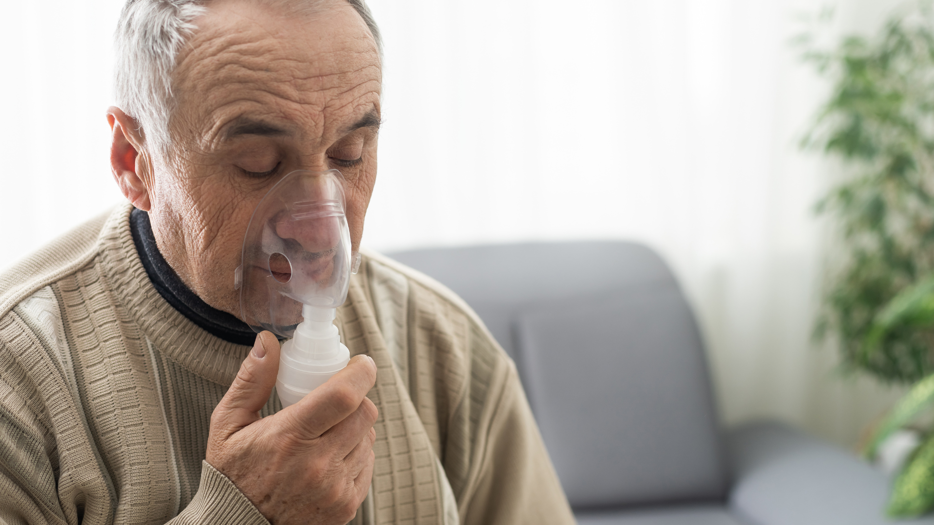 Elderly man using breathing respirator 