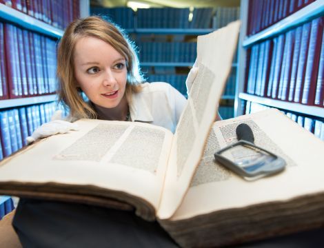 Woman viewing historic book 