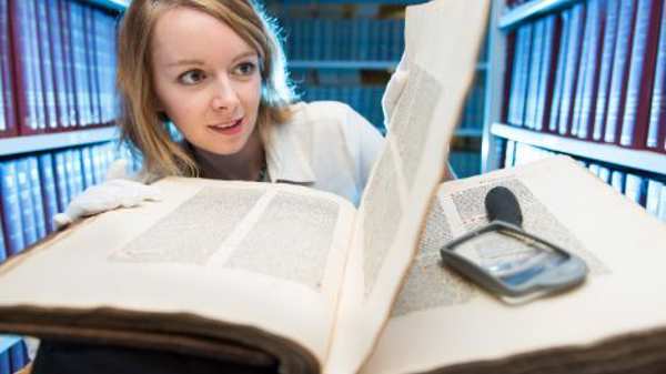 Woman viewing historic book 
