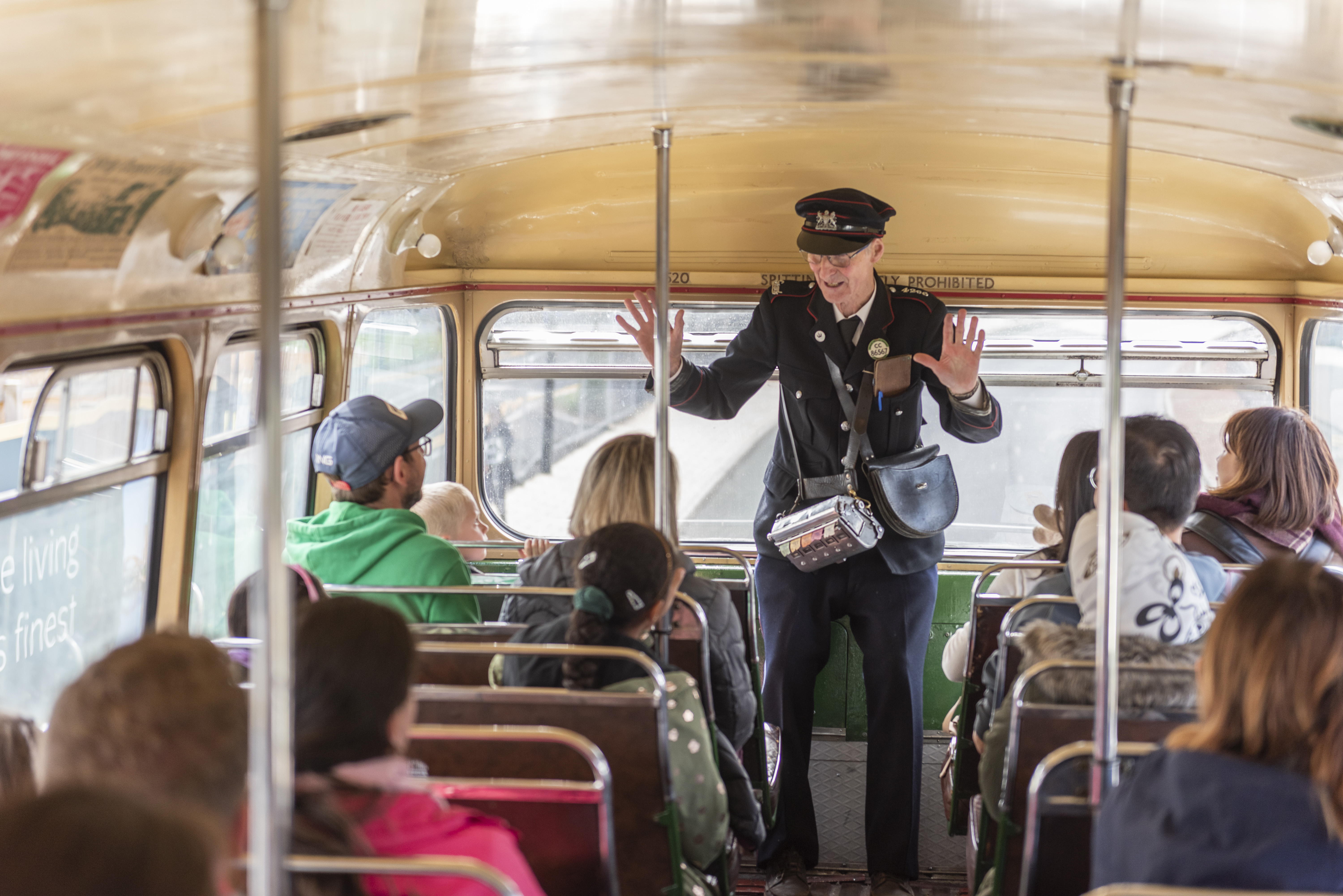 Volunteer speaking to people on vintage bus 