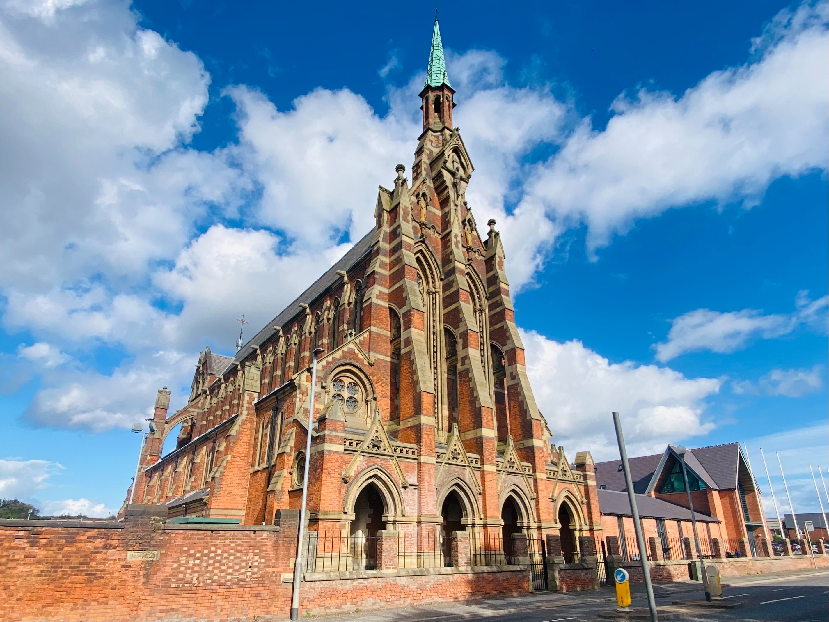 A tall red brick monastery on a sunny blue-sky day
