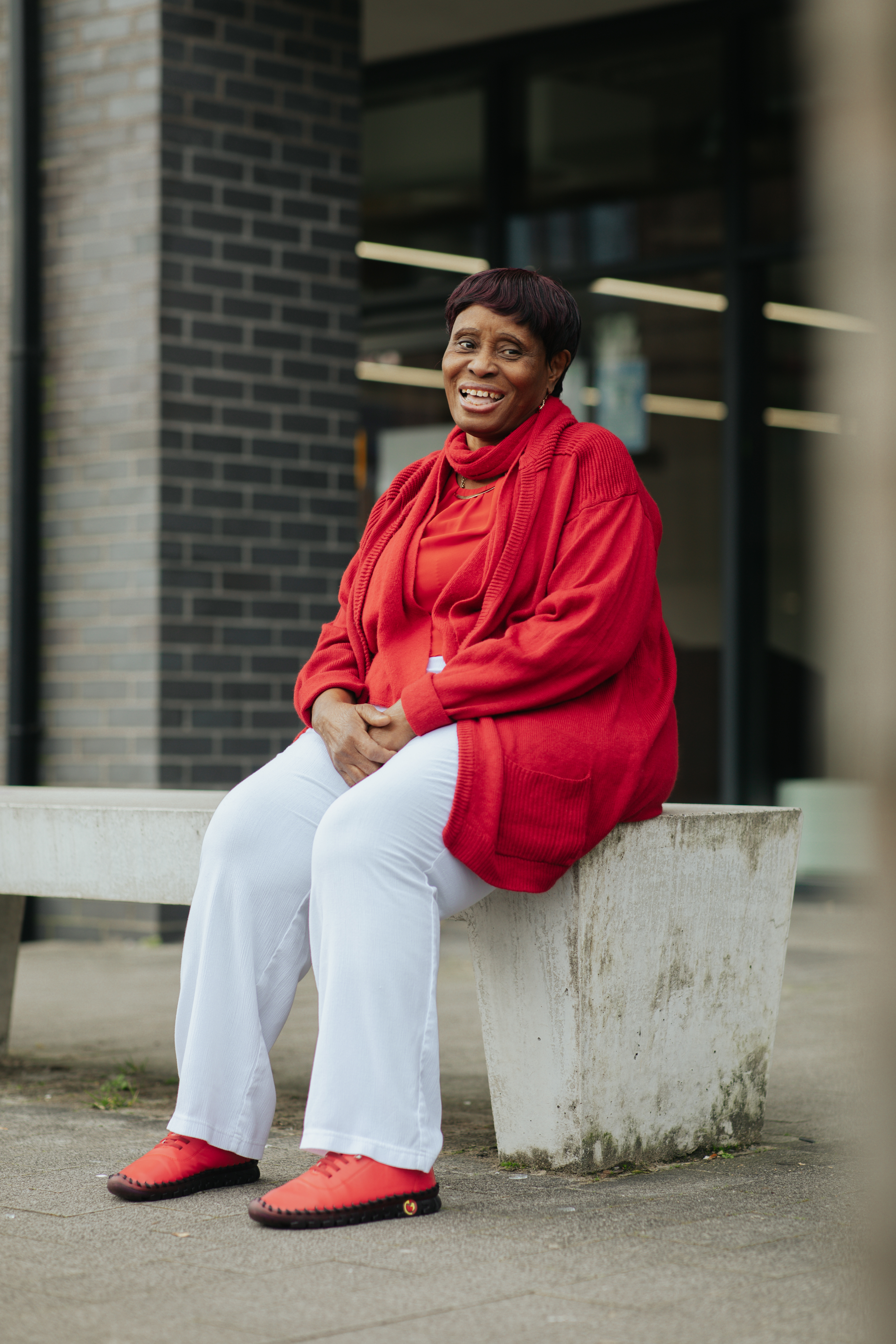 A woman sits on a bench while posing for a photo