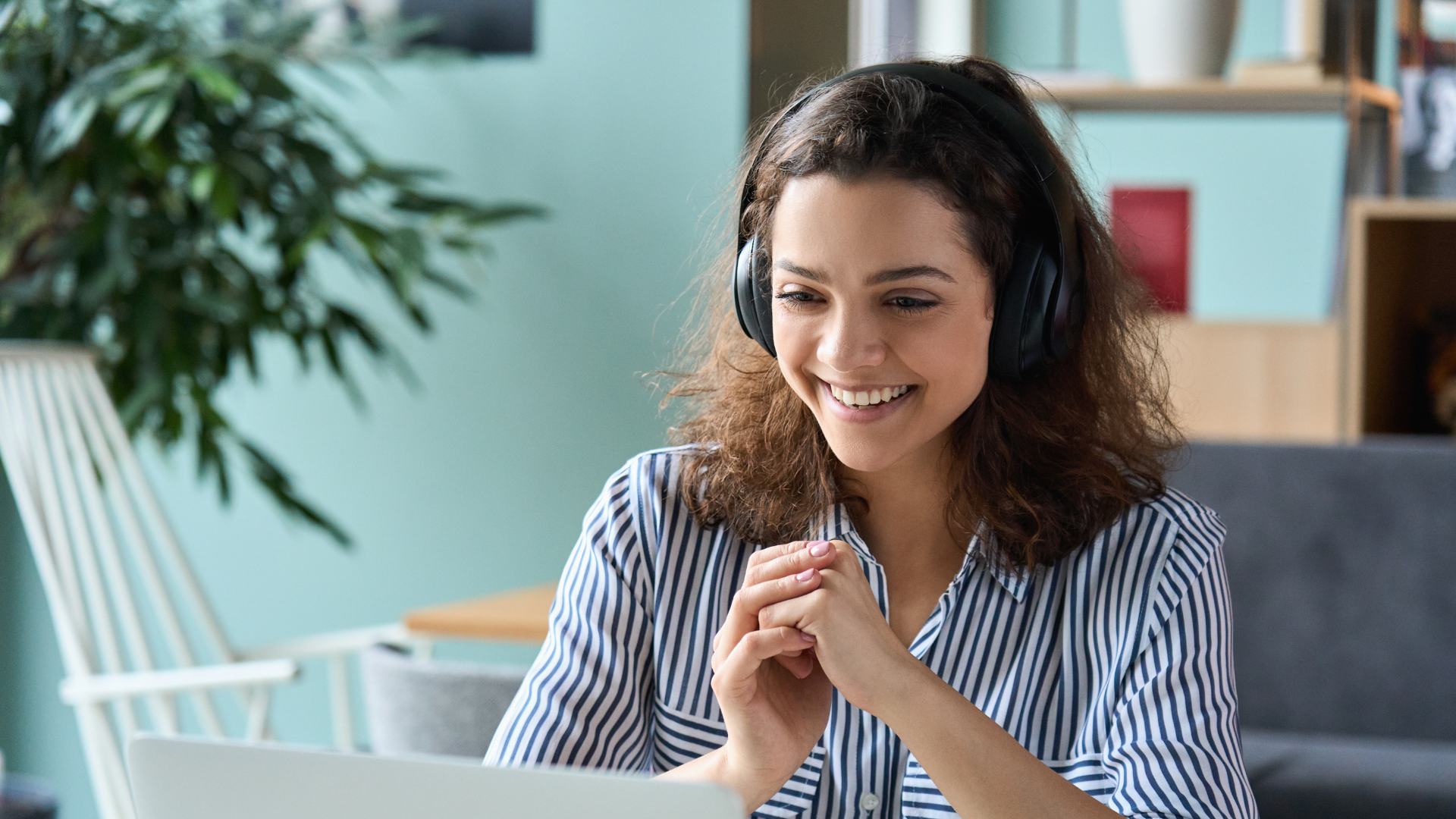 Woman sitting at laptop with headset on 