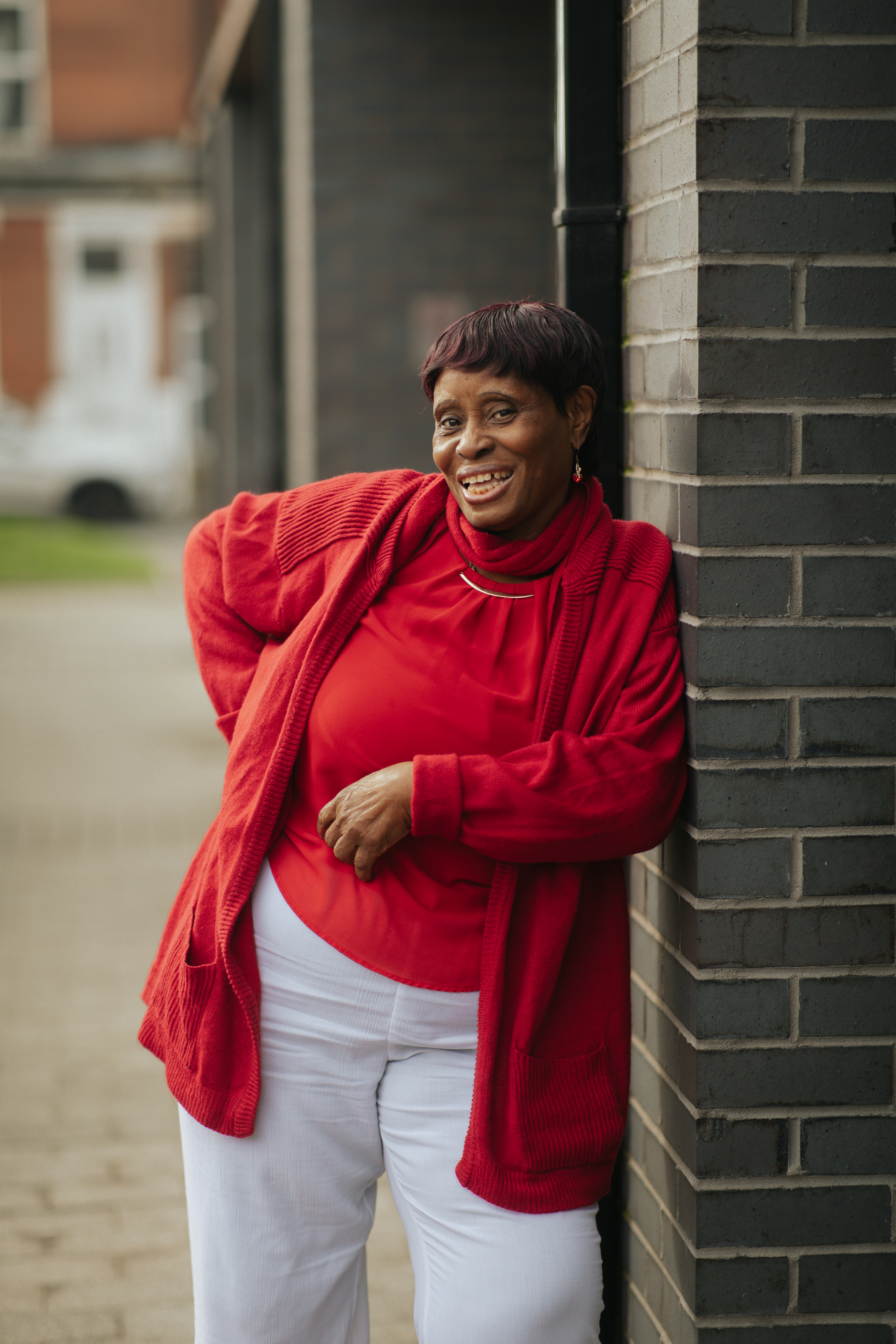 A women smiles and poses for a photo outside a community centre
