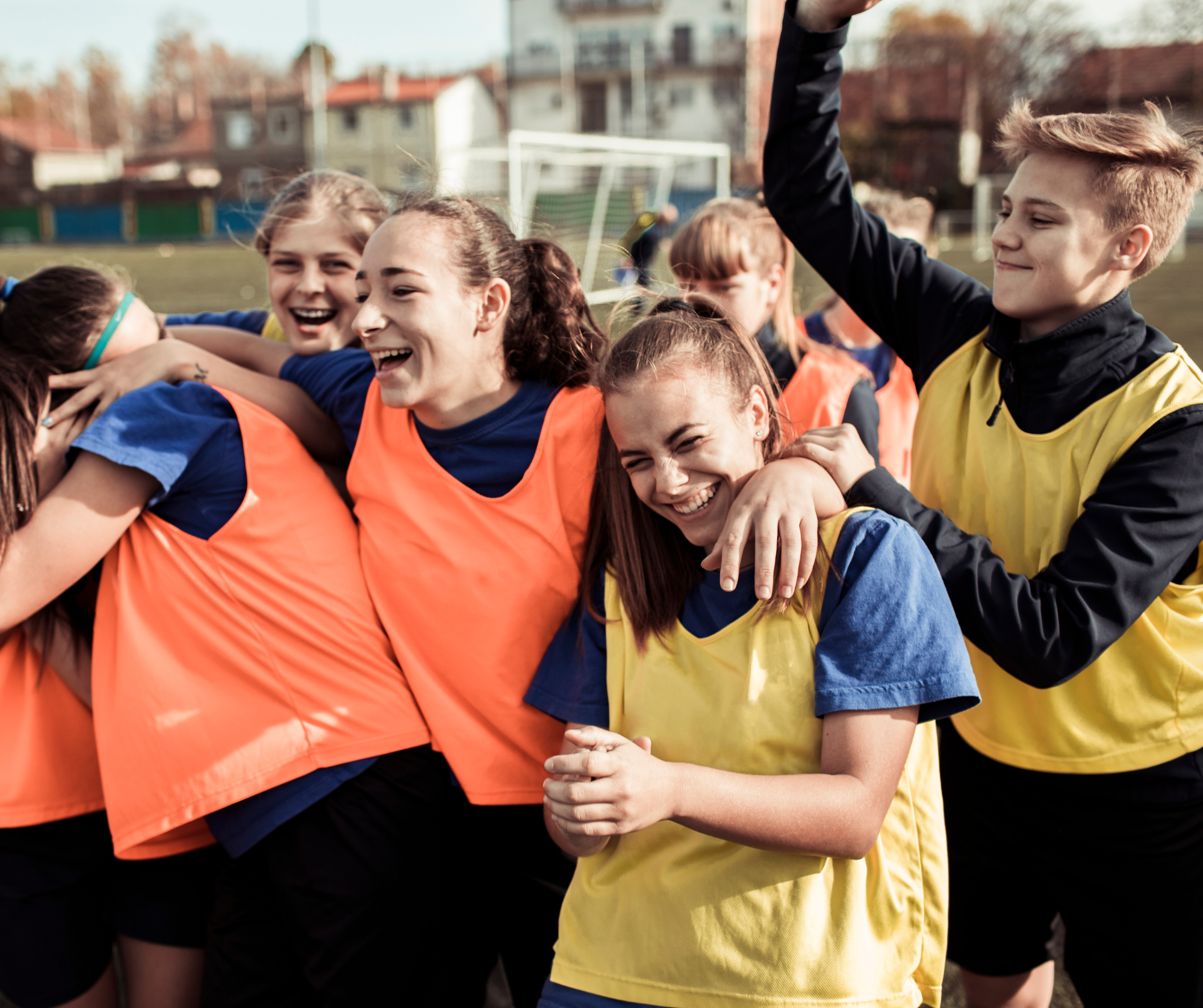A group of young people celebrating on a football pitch