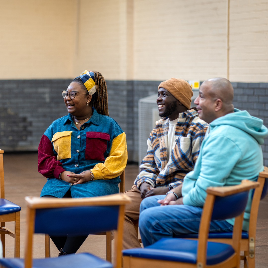 Community group sitting and chatting together in a circle of chairs