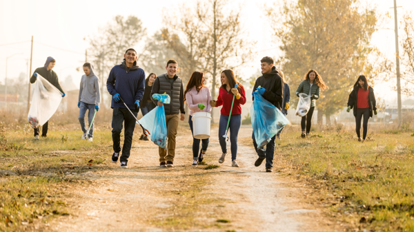 A group of wrong young people walk and collect litter at the park