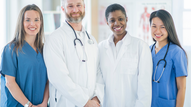 A group of doctors and nurses pose for a photo