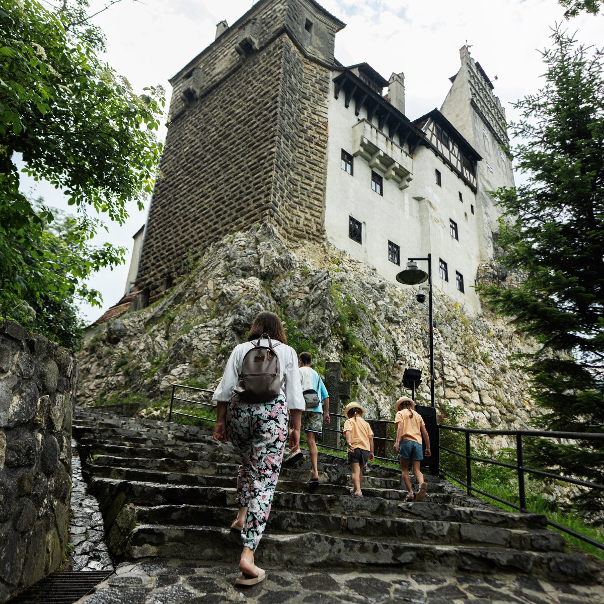 A group of people climbing up steps to visit a castle.