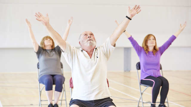 A group of people practicing chair yoga
