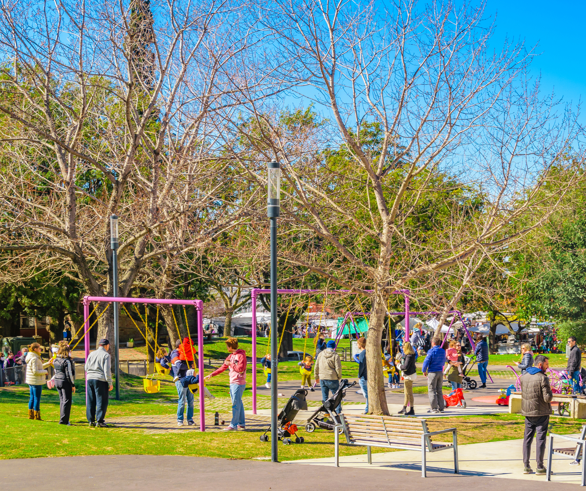 Children playing in a park surrounded by trees and grass