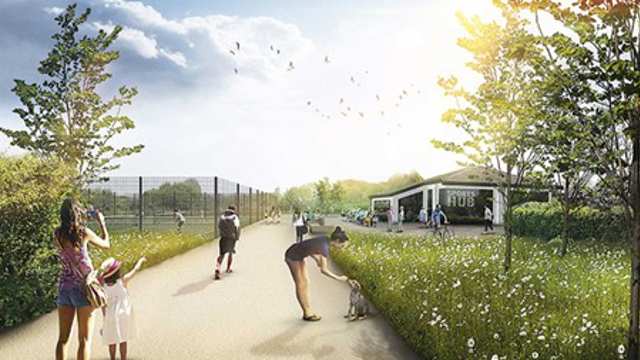 People of varying ages walk along a pathway in the park. There is a community centre and tennis courts in the background