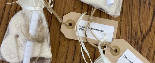 A table with clear mini drawstring bags with handcrafted hearts inside and inspirational quote tags