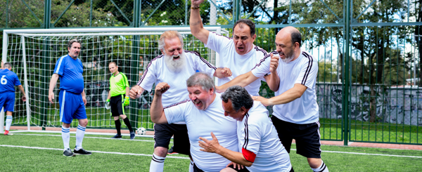 A football team of older mean celebrate a goal