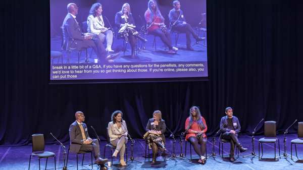 A group of people sit on a stage for a panel at the Social Prescribing Show 2023