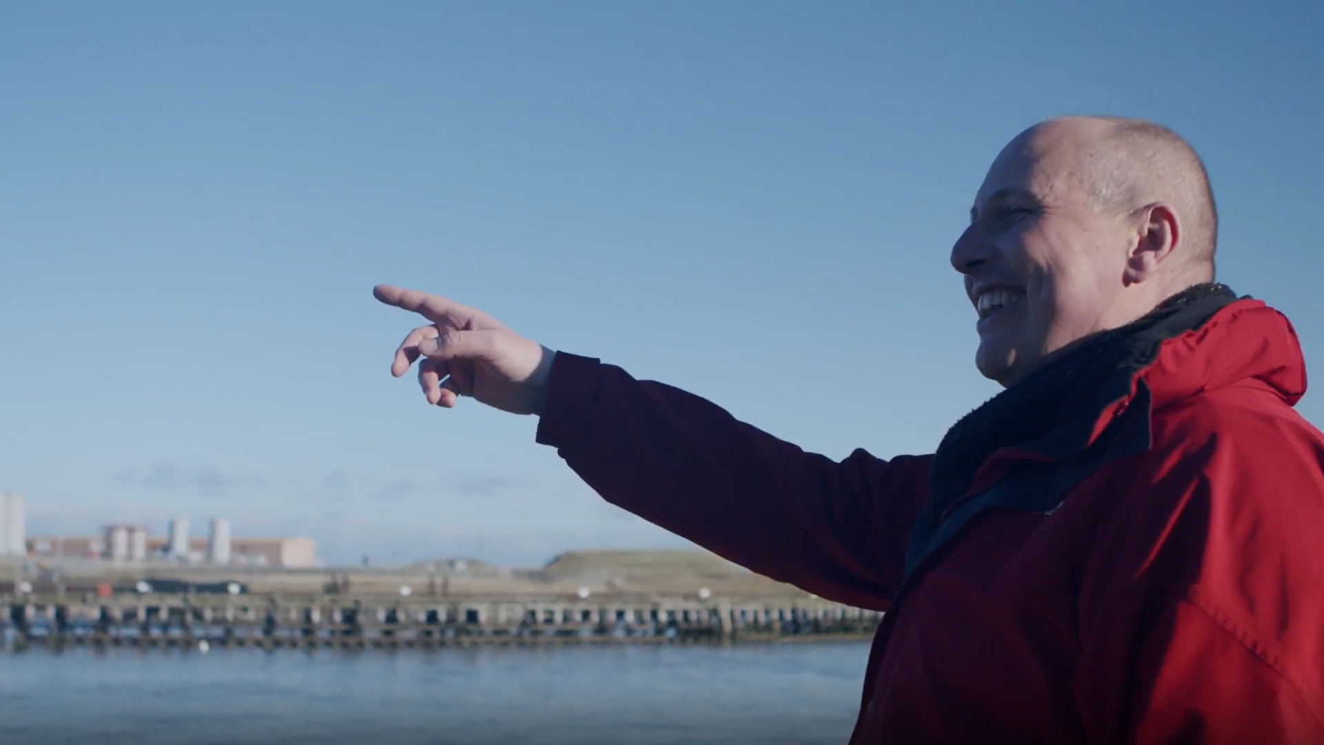 A man outside points to a distance 